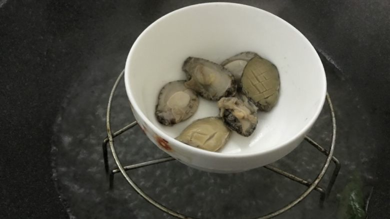 加班后的犒劳美食,家常鲍鱼仔捞饭,大火烧开水后,把鲍鱼放入蒸3-5分钟,看大小而定。不要蒸太老了。