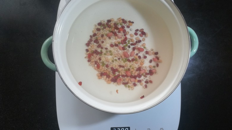红糖小米杂粮粥,锅里放入适量的水,倒入杂粮豆类等。