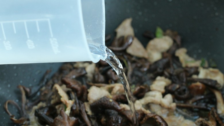 榛蘑炒肉,添入清水,盖上锅盖小火焖煮2-3分钟