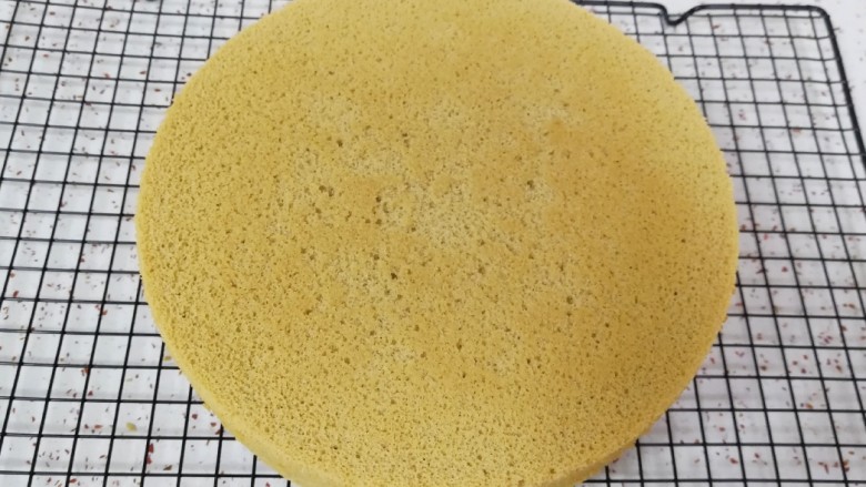 咖啡戚风蛋糕,时间到,从烤箱里取出蛋糕,垂直摔一下震出热气,倒扣在晾网上,凉透之后就可以脱模了。