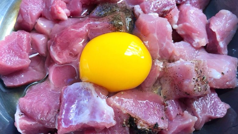 菠萝咕噜肉,里脊肉放入碗里,加入1g盐、1g黑胡椒粉、10g料酒,打入1个鸡蛋,搅拌均匀腌制5分钟