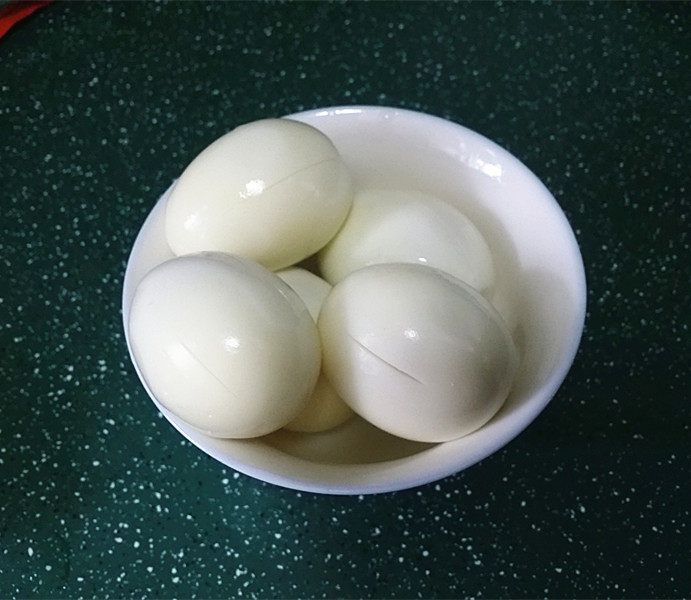 照晓鸡腿烩鸡蛋,剥去蛋壳,再用小刀在四周轻划几刀便于入味