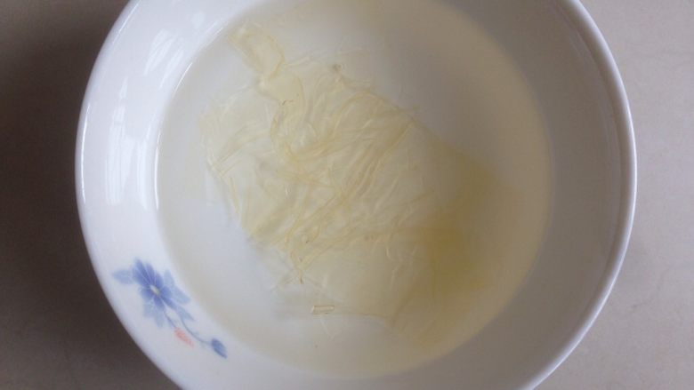 芒果牛奶布丁,先取5克的吉利丁片,泡在干净的冰水中5-10分钟