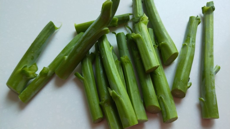 广味儿香肠\炒芥蓝花,用小刀削掉老皮,切成一长的段。