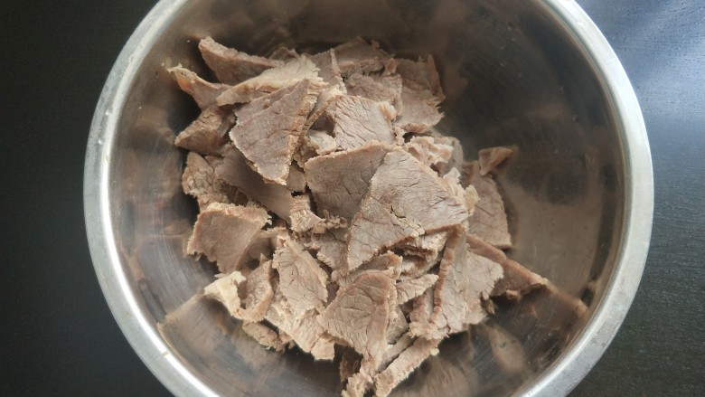 凉拌牛肉,牛肉顺着纹理切片,放入大一点的碗中。