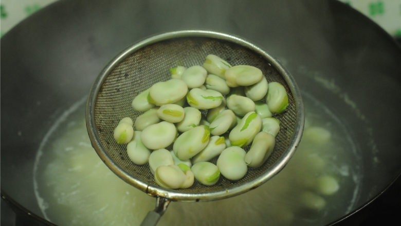 茴香蚕豆,不能确定蚕豆是否成熟,可以夹出来尝一个,蚕豆绵软后用漏勺捞出,沥干水分。