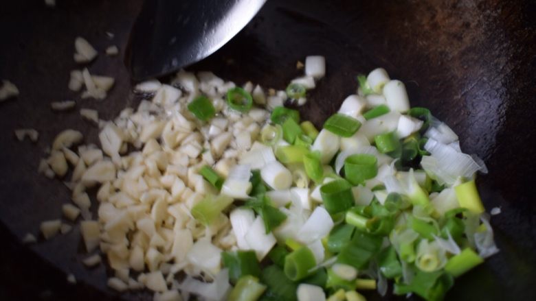 葱油小面,烧菜锅里倒入食用油,油热后,放入葱蒜,撒一些盐。