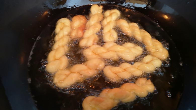 香酥小麻花,油四成热时放入麻花炸,注意用小火,且要随时翻面