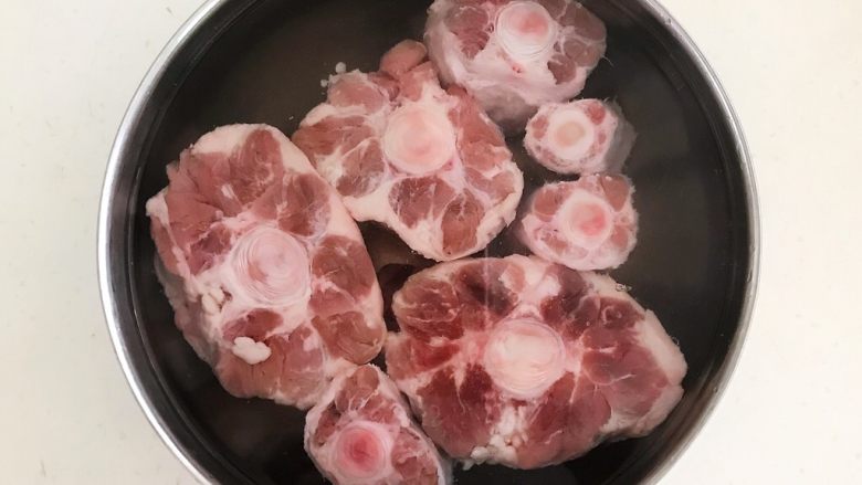 酱烧牛骨,把牛放入冷水中浸泡60分钟,每隔20分钟换一次水,泡出牛骨中的血水