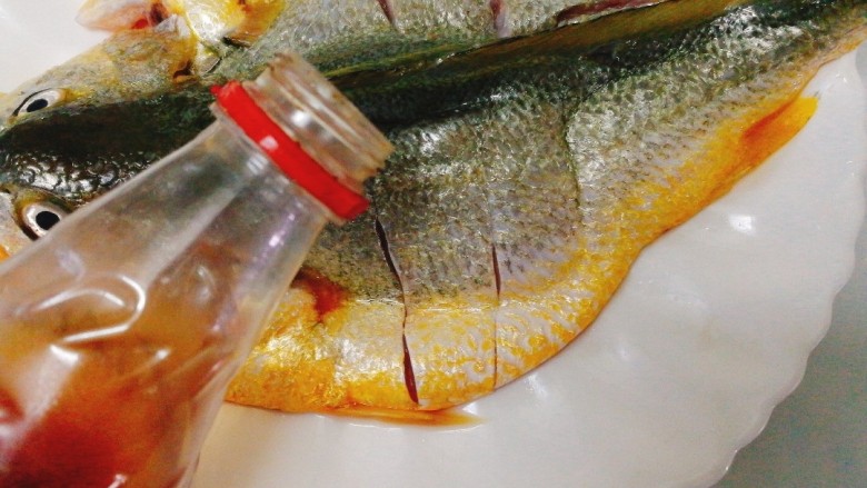 清蒸黄花鱼,加入<a style='color:red;display:inline-block;' href='/shicai/ 718'>料酒</a>腌制5分钟,(均匀的淋在鱼身上哦)