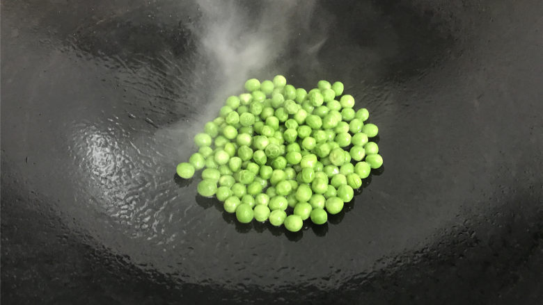 豌豆草菇虾仁,锅中倒入适量油,放入焯过水的豌豆先爆一下。