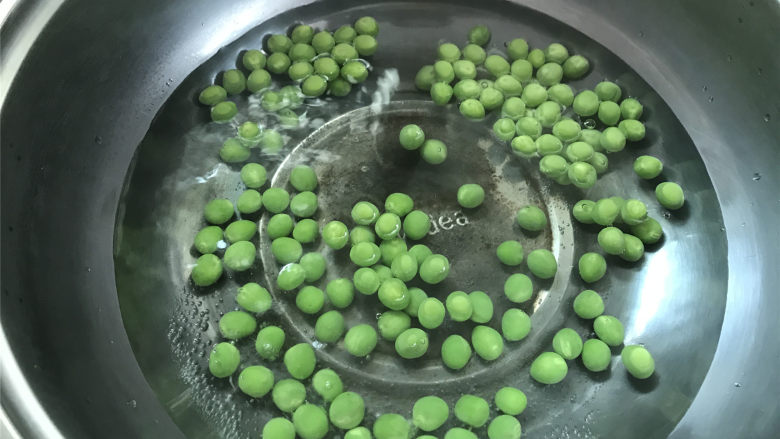 豌豆草菇虾仁,先把清洗干净的豌豆放入开水中焯下水,焯的过程中加少许盐,可保持豌豆的翠绿。