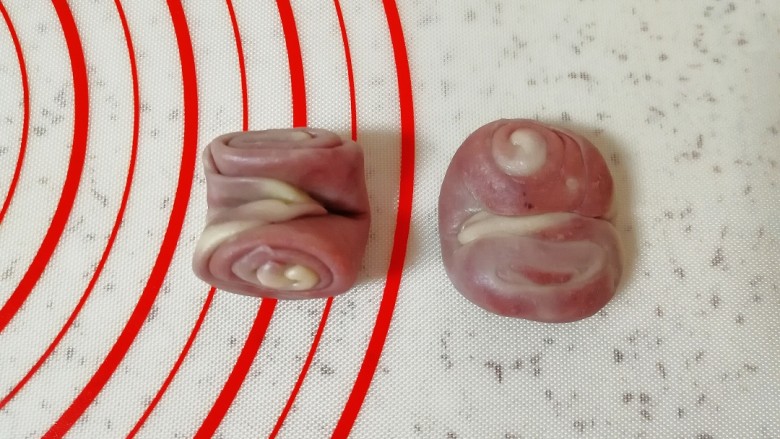 紫薯桃花酥,取一个松弛好的卷卷,用筷子从中间压一下,两头向上压扁。