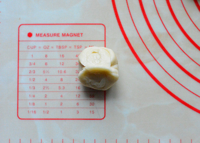 蛋黄酥,松弛完毕后，取1个酥皮，先在收口处中间按压一下，两边捏起