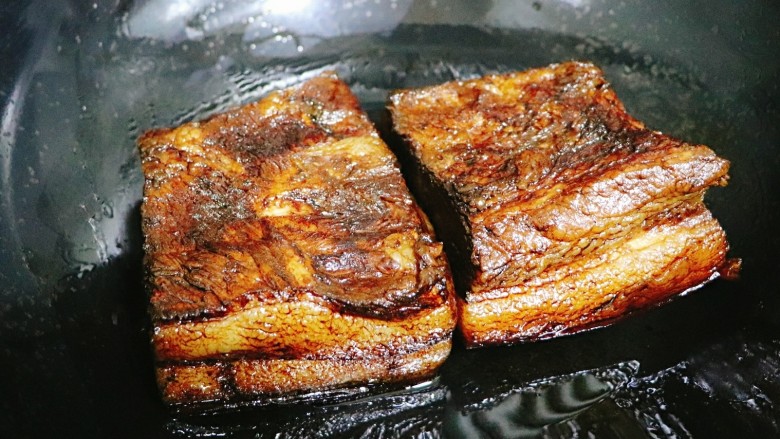 梅干菜扣肉,待表面老抽干了,肉皮朝下放入油锅,少许一点油,盖上盖小火煎三两分钟。