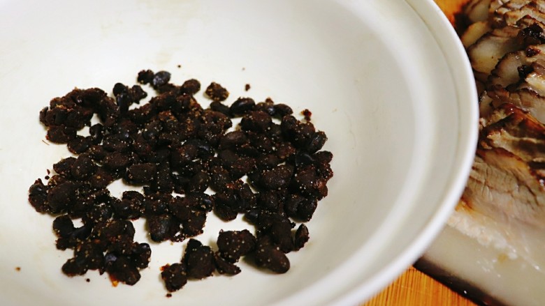 梅干菜扣肉,取一个大碗,倒入<a style='color:red;display:inline-block;' href='/shicai/ 694'>豆豉</a>铺底。