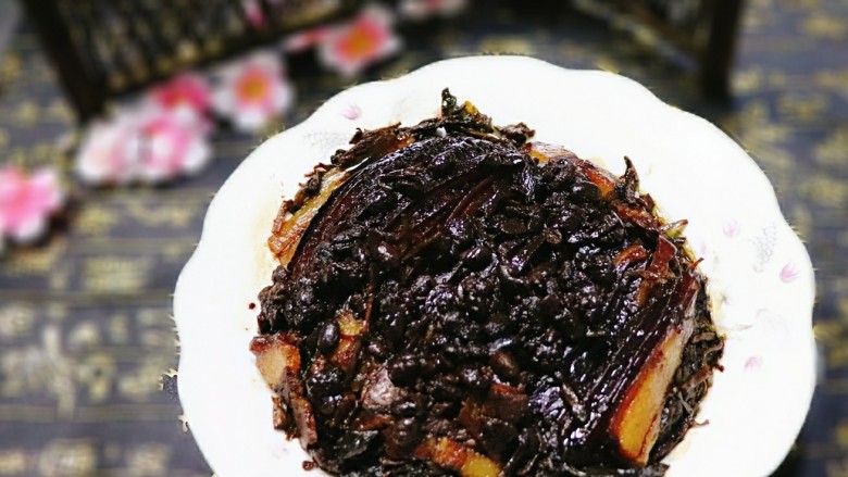 梅干菜扣肉,把盘子里的汤和油倒出,放在锅中加水淀粉勾芡,浇在肉片上,即可。