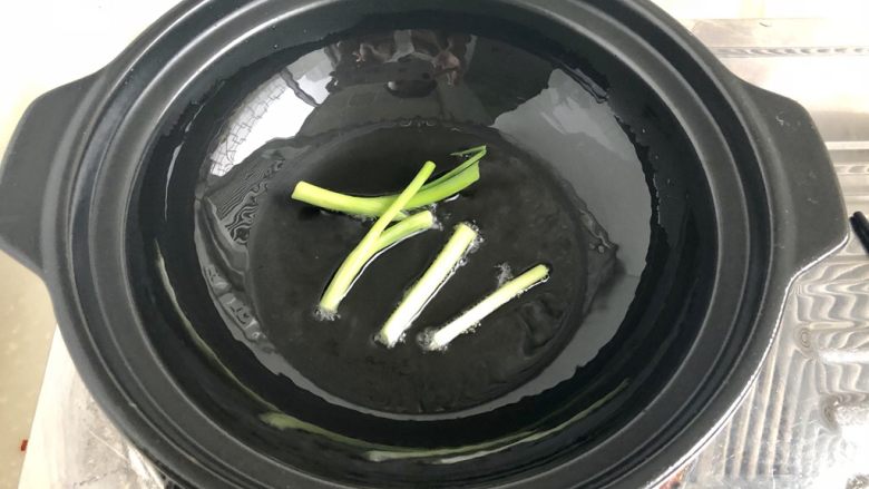 偷懒版香喷喷煲仔饭➕烤鸭香肠煲仔饭,取一个煲仔饭砂锅或如阿晨这样的干烧煲,小火热锅,然后加入少许食用油,加入葱段煸香