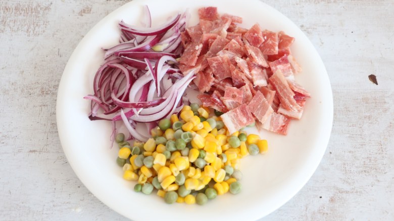 培根披萨,准备配料。 <a style='color:red;display:inline-block;' href='/shicai/ 443'>培根</a>切小块，<a style='color:red;display:inline-block;' href='/shicai/ 29'>洋葱</a>切细丝，玉米<a style='color:red;display:inline-block;' href='/shicai/ 148'>豌豆</a>开水焯烫熟。