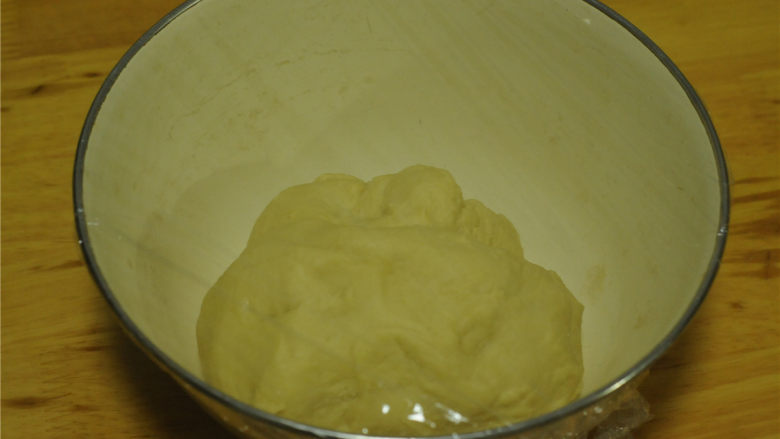 无黄油版绵软奶油紫薯面包,中种面团里的食材混合,揉成团后放在容器里,盖上保鲜膜,放在冰箱里冷藏发酵