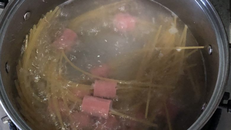 万箭穿肠意面(串肠意面),水烧开,放入串好的意面,大火烧开转小火慢煮10分钟左右,具体根据各品牌说明煮透即可,由于有段意面夹在火腿肠中,要比平时多煮两分钟哦!