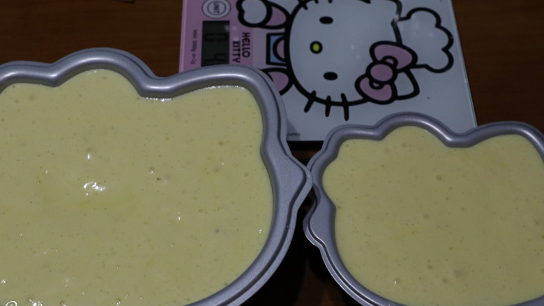 香草kitty轻芝士蛋糕,倒入KITTY蛋糕模具中,放抹布上轻振去大气泡。模具无需铺油纸。