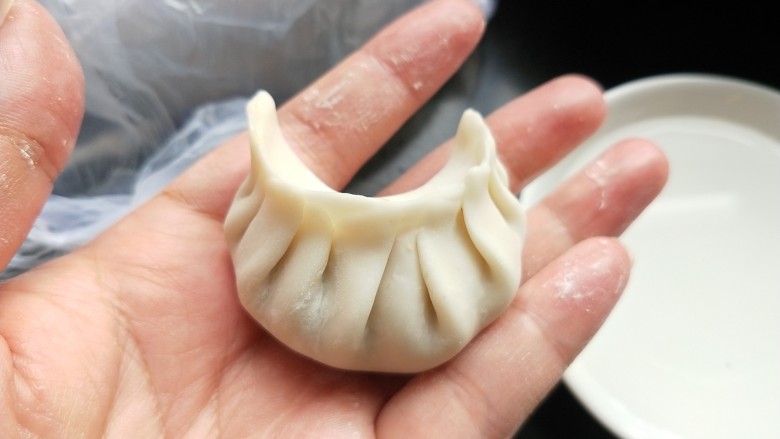 豆角猪肉馅饺子,捏出一个个褶子,包好。