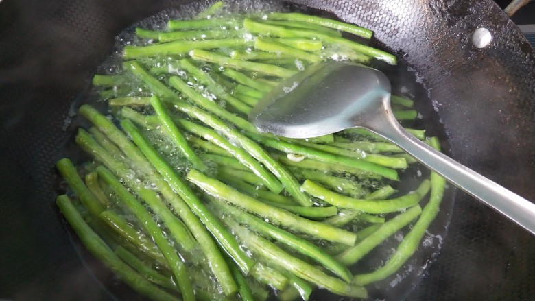 豆角猪肉馅饺子,豆角放入水开后焯水五分钟,捞出,放冷水中冲洗一下。