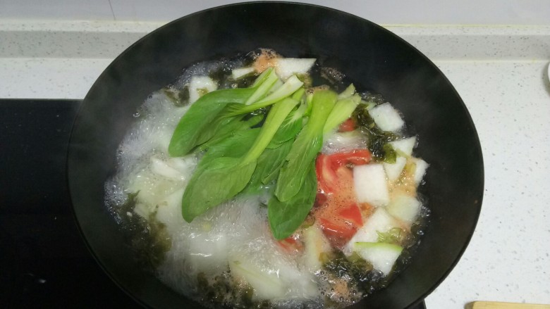 紫菜虾米冬瓜西红柿青菜汤,待西红柿煮1分钟,加入青菜。