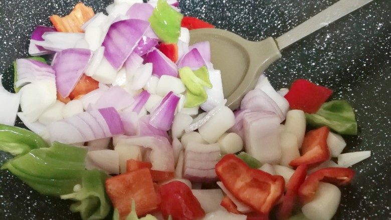 黑椒鸡肉粒,锅洗干净,从新倒入油,八成热时把洋葱,青红辣椒,手指年糕放进锅里翻炒