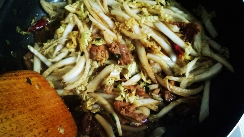 白菜炒香干,继续翻炒,炒至白菜变软。