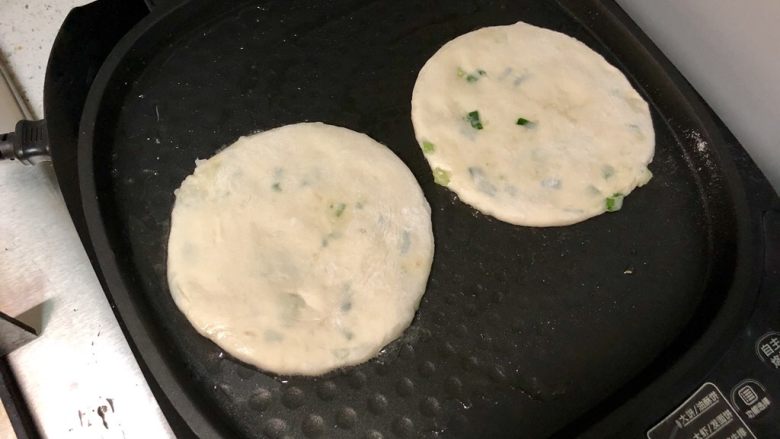 发面葱油饼,把面饼房进电饼铛，盖上盖子，用“大饼”模式开始烙制。