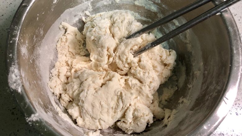 发面葱油饼,加入200克面粉,用筷子拌成絮状。