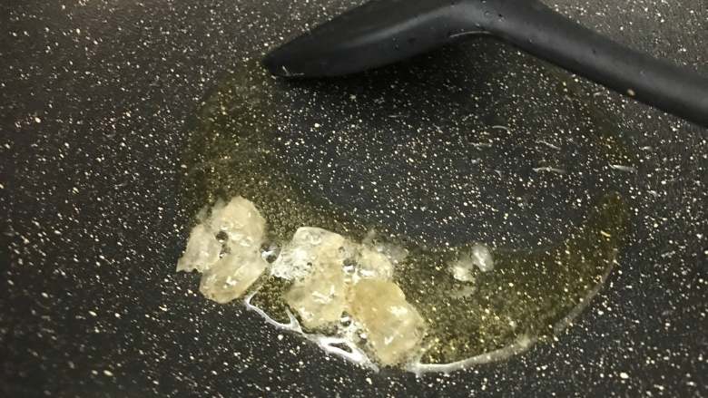 红烧猪蹄,将爆香好的香料取出,油剩在锅中,加入适量冰糖,中小火加热至融化。