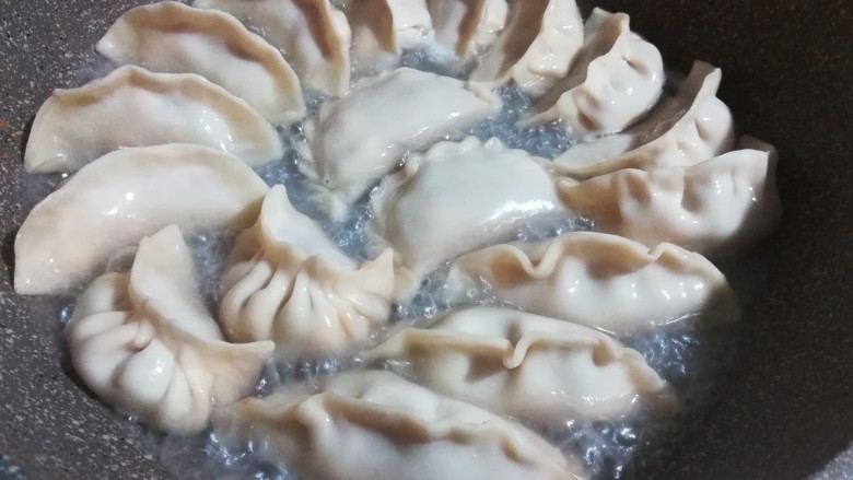 花式三色煎饺,包好后放入平底锅中。先小火煎至底壳稍稍变硬。然后加入半杯水,水量大约平锅底就可以。
