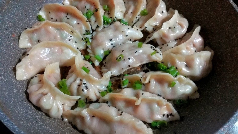 花式三色煎饺,煎至饺子的底壳金黄,撒上葱花和芝麻,大约需要八分钟左右。具体煎制的时间,要根据饺子的大小和馅料来适当的调整。