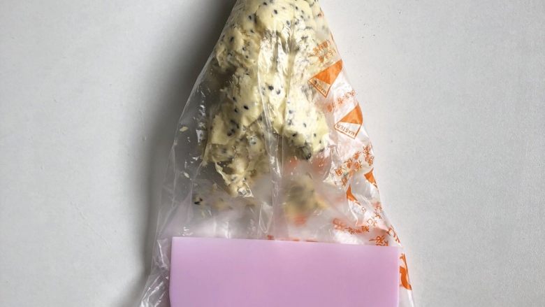 黑芝麻咸香曲奇,装入套上裱花嘴的裱花袋,用刮板刮平