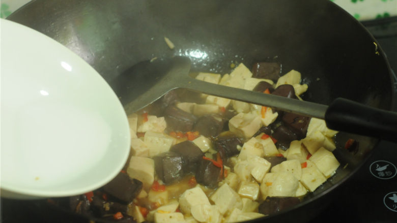 双色 豆腐,沿着锅边淋入少许水,烧开