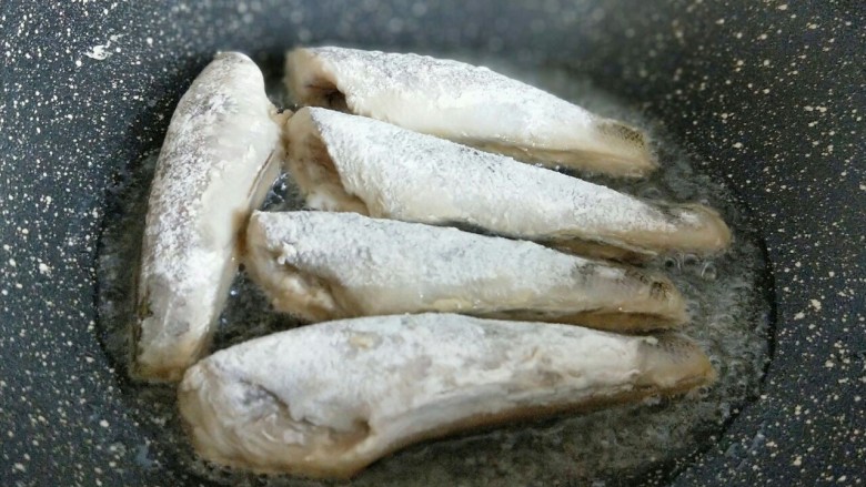 #做妈妈的拿手菜#红烧冰鱼段,起油锅,加入适量食用油,放入裹上面粉的南极冰鱼段。