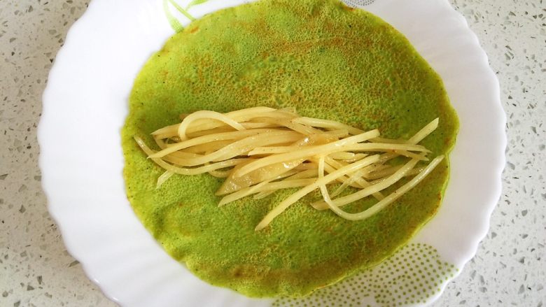黄瓜煎饼卷土豆丝,煎饼反面朝上,卷入土豆丝,切两半