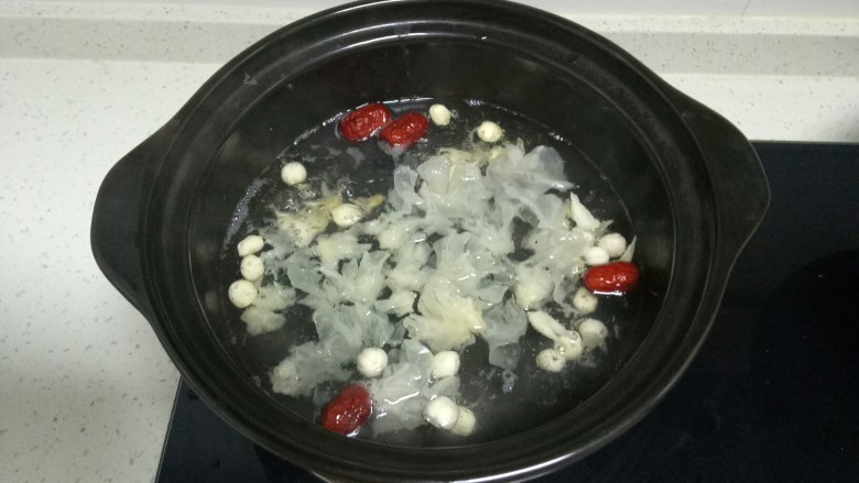 银耳莲子百合红枣冰糖羹,大火烧开,将银耳去黄根,用手撕成小朵加入锅中,待再次水开后,转小火煮40分钟。