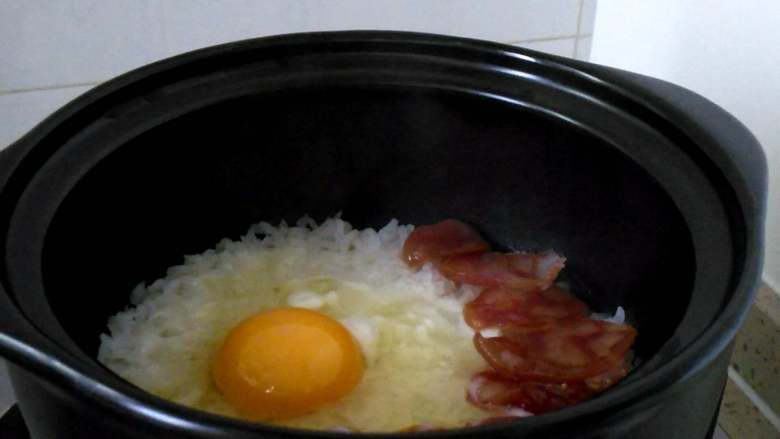 腊味煲仔饭,腊肠基本成熟,米饭开始出现小洞时,打入一个鸡蛋。