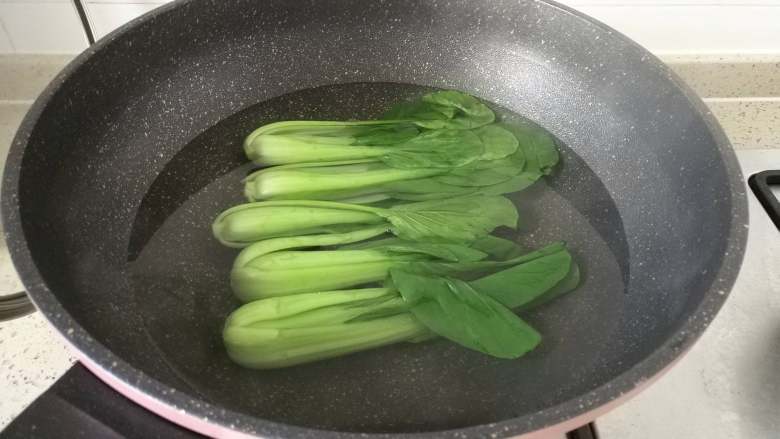 腊味煲仔饭,炒锅烧开水,里面加少许盐,食用油,把洗好的油菜焯烫30秒捞出。