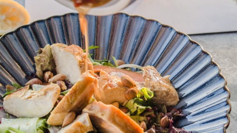 香辣鸡胸肉沙拉,蔬菜放在盘底,再将鸡肉摆上去,撒上少许的坚果,最后再淋剩下的香辣汁。