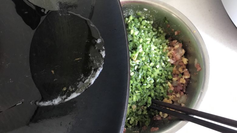 鲜虾鲜肉韭菜饺子,刚才煎鸡蛋的油晾凉后倒入到馅中搅拌均匀,按同一方向搅拌好。