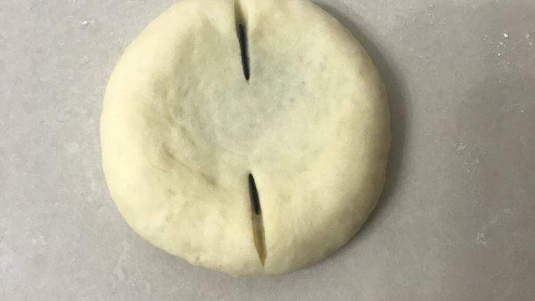 豆沙花朵面包,用手掌按扁尽量按圆一些,用割包刀割口
