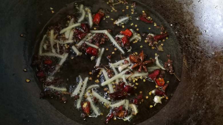 酱爆香辣钉螺,锅内放油,油热把干辣椒、花椒、八角、姜、蒜放入爆香。