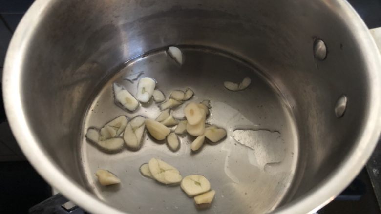 小奶锅煮日式南瓜,加入蒜片,转小火略煎。