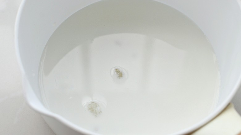 芒果布丁,奶锅中倒入牛奶和细砂糖,小火加热至糖融化