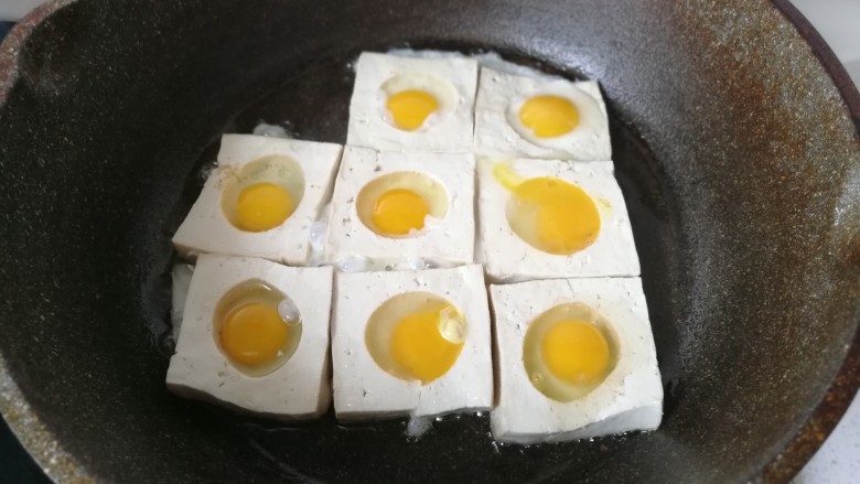 糖醋鹌鹑蛋豆腐,然后再把鹌鹑蛋打碎,填入豆腐的圆孔中,开中小火煎制。